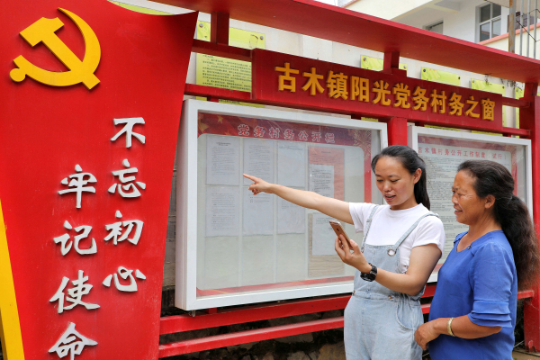已編輯圖為古木鎮紀檢監察干部和群眾監督員在核對微信群里發布的內容是否與公示欄里張榜的內容相符合。（王銘堅 攝）.jpg
